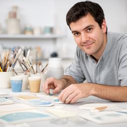 Noah Riedi am Arbeitstisch mit Glasurmuster und Messbecher